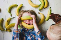 Chica cubierta de plátanos - foto de stock