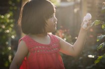 Девушка с лепестками роз в руке — стоковое фото