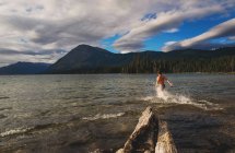 Man running into lake — Stock Photo