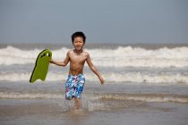 Niño corriendo en el mar - foto de stock