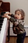 Petit garçon chantant et jouant du piano — Photo de stock