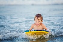 Niño pequeño en la tabla de surf - foto de stock