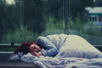 Молода жінка спить у автобусному притулку — стокове фото