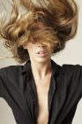 Donna flipping lunghi capelli biondi — Foto stock