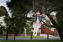 Fille jouer sur swing dans le parc — Photo de stock