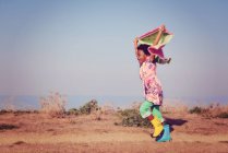 Девушка бежит с красочным шарфом — стоковое фото