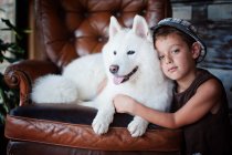 Retrato de niño con perro samoyedo - foto de stock