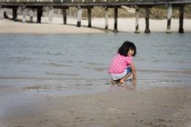 Chica jugando en la playa de arena - foto de stock