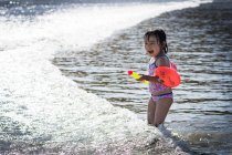 Mädchen spielt in welligem Meer — Stockfoto