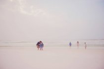 Família obtém prazer de passatempo na praia — Fotografia de Stock