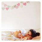Menina com cabelo preto deitado na cama — Fotografia de Stock