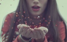 Girl blowing confetti — Stock Photo