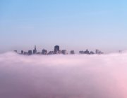 Хмарочоси, які видно над пухнастими хмарами — стокове фото