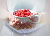 Hand holding raspberries — Stock Photo