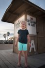 Menina em pé na frente da estação de salva-vidas — Fotografia de Stock