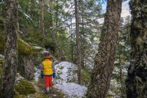 Junge läuft im Winter durch Wald — Stockfoto