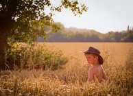 Хлопчик носити капелюх стоячи — стокове фото
