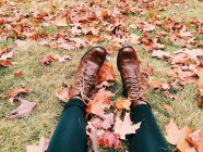Stivali femminili appoggiati sulle foglie — Foto stock