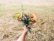Hands holding bouquet flowers — Stock Photo