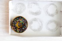 Donut dulce de chocolate en caja vacía - foto de stock