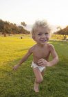 Baby in Windel läuft auf Feld — Stockfoto