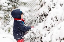 Мальчик играет на улице зимой — стоковое фото