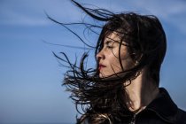 Jeune femme avec les cheveux soufflant sur le vent — Photo de stock