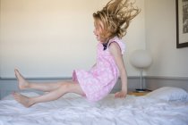 Mädchen prallt auf Bett — Stockfoto