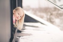 Mädchen schaut aus dem Fenster — Stockfoto