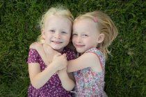 Две девушки обнимаются на траве — стоковое фото