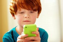 Мальчик играет в мобильную игру — стоковое фото