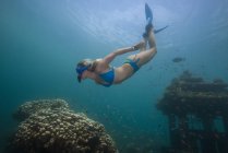Woman snorkeling exploring sunken temple — Stock Photo