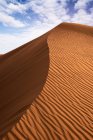 Dune ondulée de sable au coucher du soleil — Photo de stock