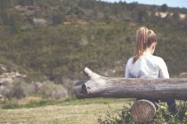 Mädchen lehnt an Baumstamm — Stockfoto