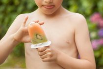 Хлопчик тримає фруктовий лід повністю — стокове фото