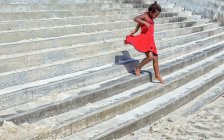 Девушка в платье бежит по ступенькам — стоковое фото
