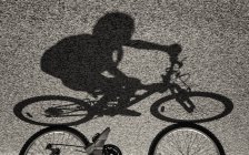 Ombra di ragazza in sella bicicletta — Foto stock