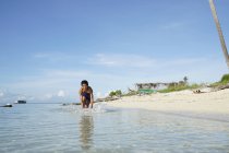 Улыбающийся мальчик играет на пляже — стоковое фото