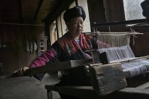 Chinese woman weaving fabric — Stock Photo