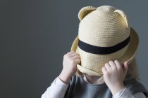 Menina puxando chapéu para baixo sobre a cara — Fotografia de Stock