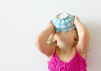 Menina segurando tigela de cereais para boca — Fotografia de Stock