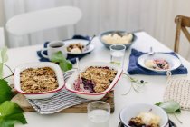 Table laid with blueberry crumble — Stock Photo