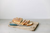 Pan rebanado en la tabla de cortar - foto de stock