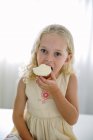 Menina comendo cupcake de limão — Fotografia de Stock