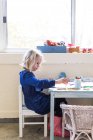 Маленькая девочка рисунок на столе — стоковое фото