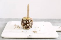 Chocolate and nuts coated apple — Stock Photo