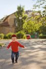 Малыш бежит по улице — стоковое фото