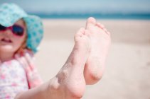 Girl showing off sandy toes — Stock Photo