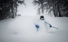 Esquiador masculino disfrutando del esquí en polvo profundo - foto de stock