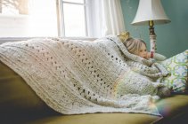 Девушка сидит под одеялом — стоковое фото